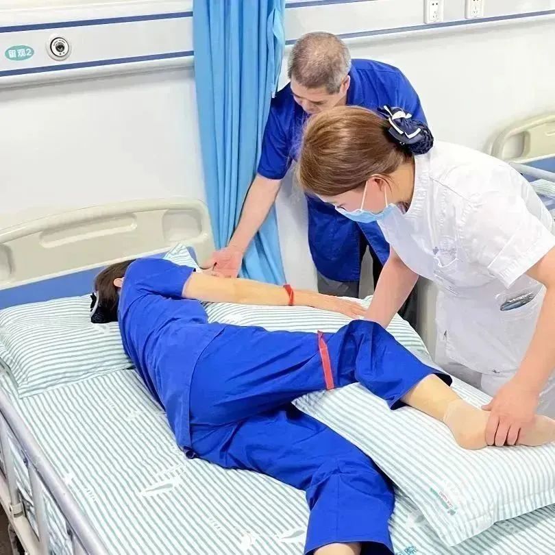 康复护士在培训演示偏瘫病人良肢位摆放